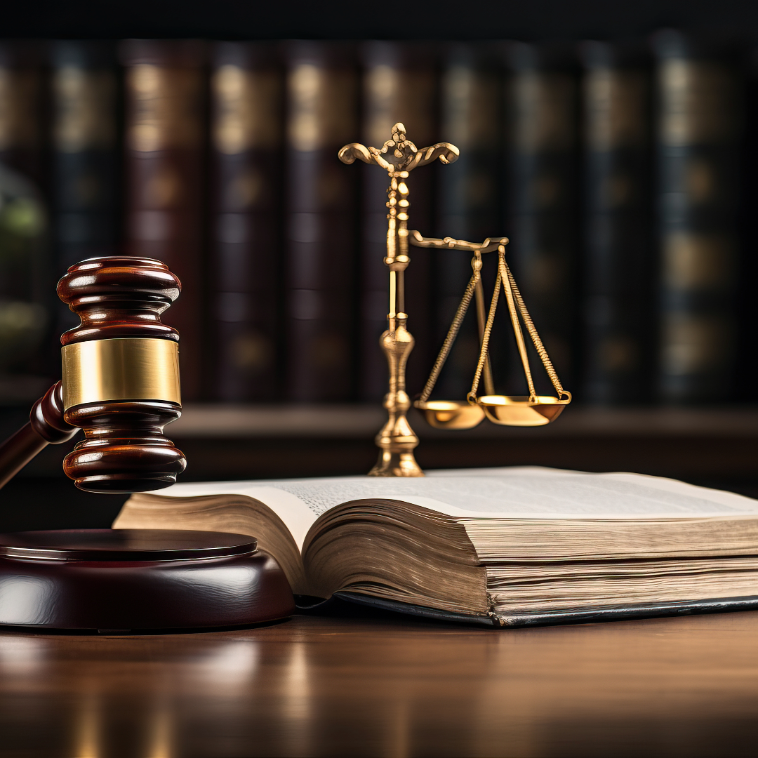 Wooden gavel and legal scales in a law office setting.