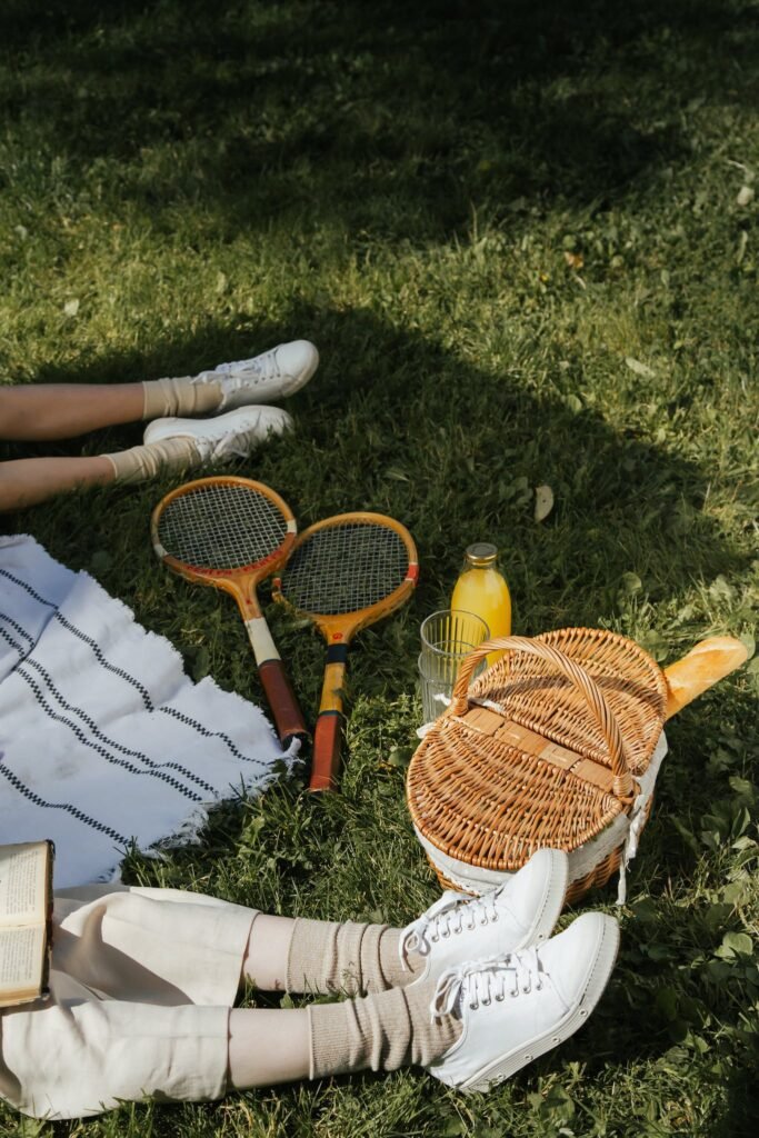 Picnic basket with tennis rackets symbolizing leisure time.